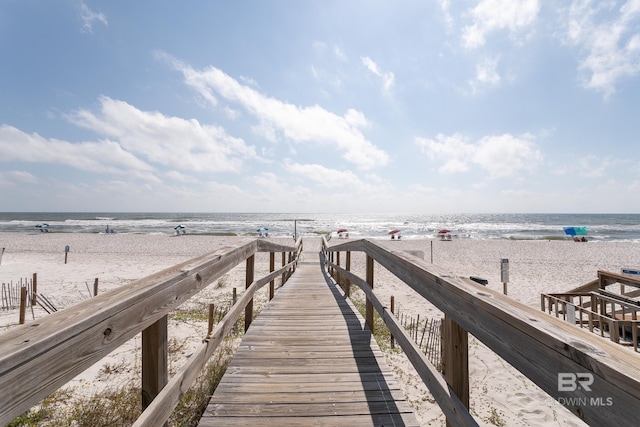 dock area with a water view and a beach view