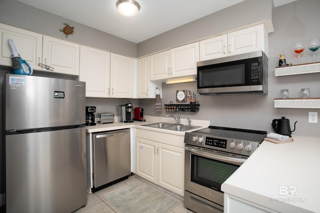 kitchen featuring white cabinetry, light tile patterned floors, stainless steel appliances, and sink