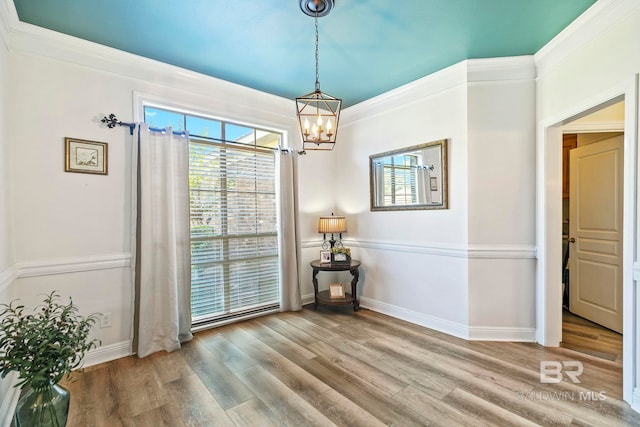 dining room with crown molding, hardwood / wood-style floors, and a chandelier