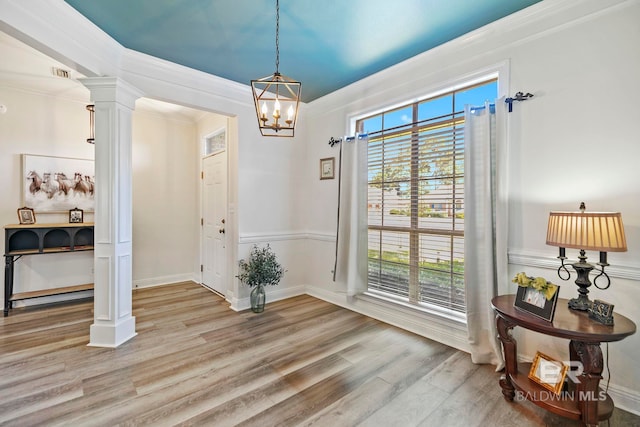 doorway to outside featuring light hardwood / wood-style flooring, a healthy amount of sunlight, and ornate columns