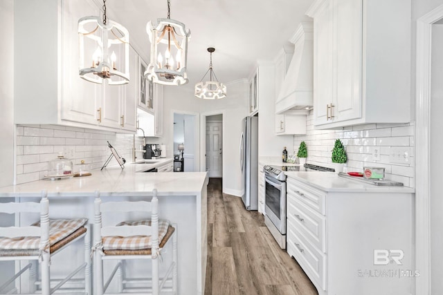 kitchen with stainless steel appliances, decorative backsplash, light wood-type flooring, kitchen peninsula, and custom exhaust hood