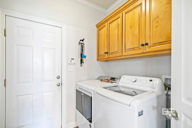 laundry room with washing machine and dryer, crown molding, and cabinets