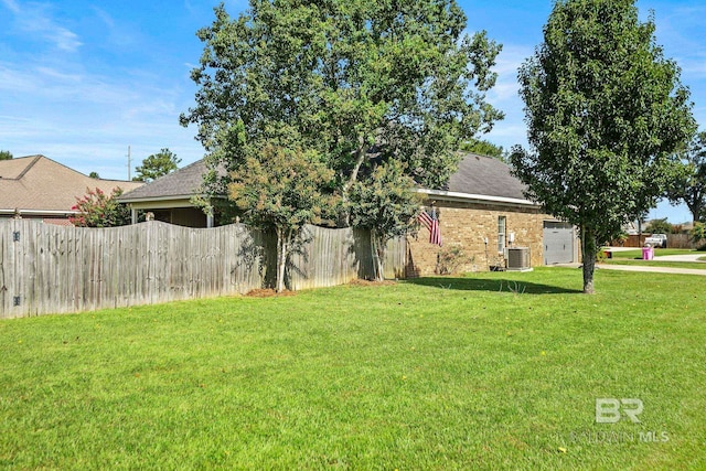 view of front of house featuring a garage, central air condition unit, and a front yard