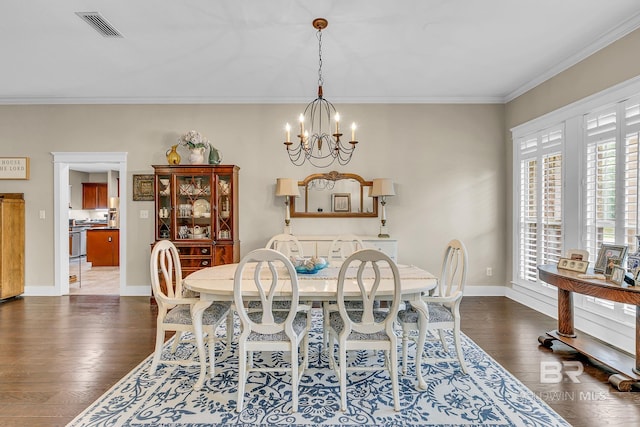 dining area featuring dark wood-type flooring, crown molding, and a notable chandelier