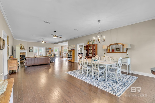 dining room with dark hardwood / wood-style flooring, crown molding, and an inviting chandelier