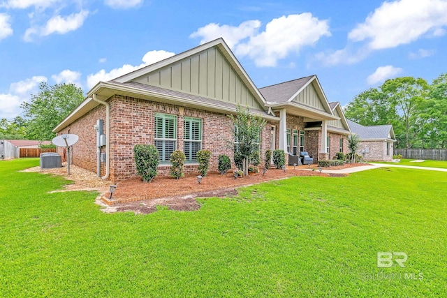 view of front of property with a front yard and central AC unit