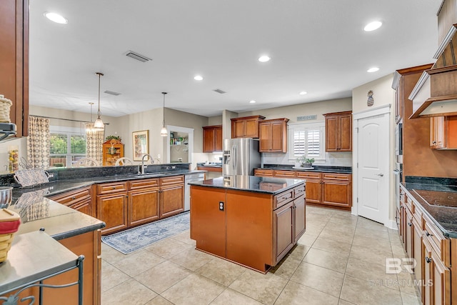 kitchen with stainless steel fridge with ice dispenser, sink, a kitchen island, kitchen peninsula, and pendant lighting