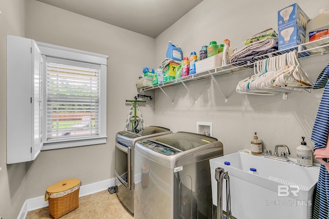 washroom with sink, light tile patterned flooring, and washer and clothes dryer