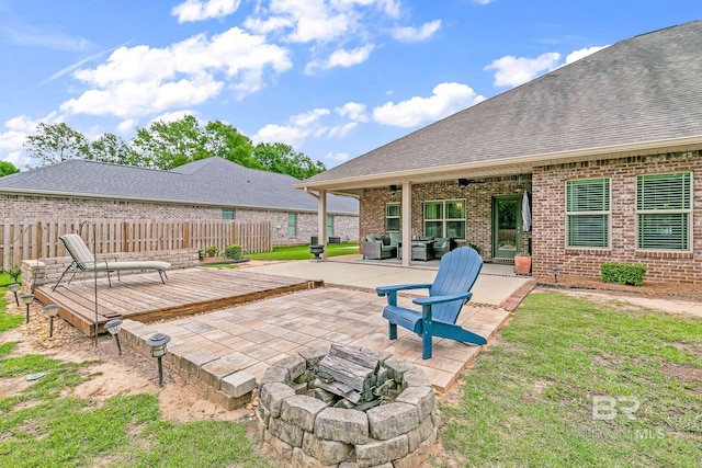 view of patio featuring a deck, ceiling fan, and an outdoor living space with a fire pit