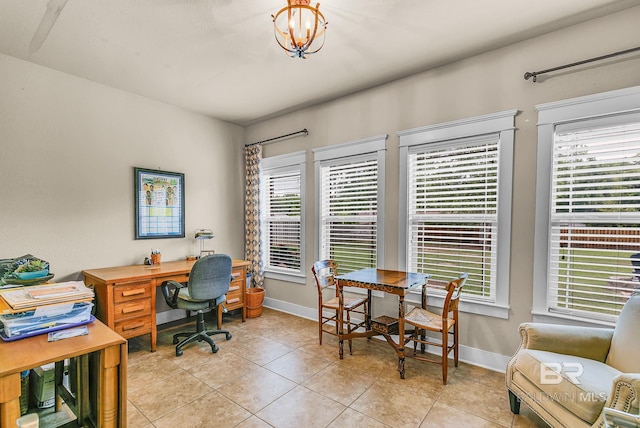 office space with an inviting chandelier, light tile patterned floors, and a wealth of natural light