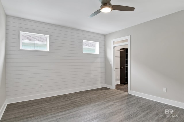 unfurnished room featuring dark wood-type flooring, ceiling fan, and plenty of natural light