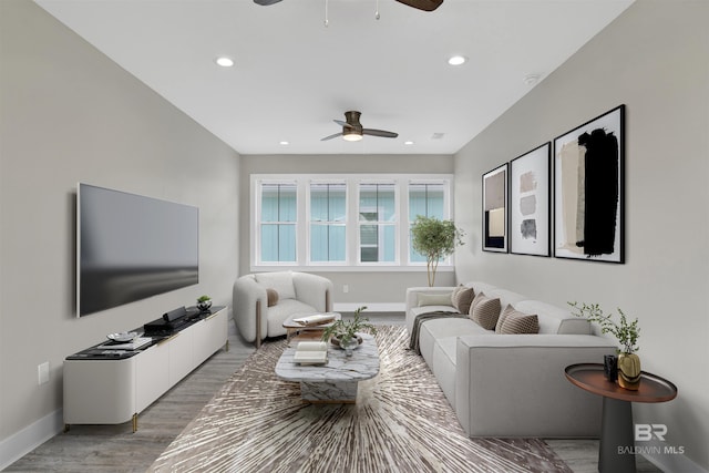 living room featuring ceiling fan and hardwood / wood-style flooring