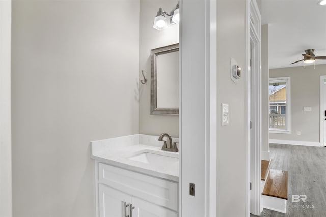 bathroom with ceiling fan, vanity, and hardwood / wood-style floors