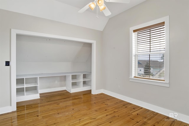 interior space with lofted ceiling, built in features, wood-type flooring, and plenty of natural light