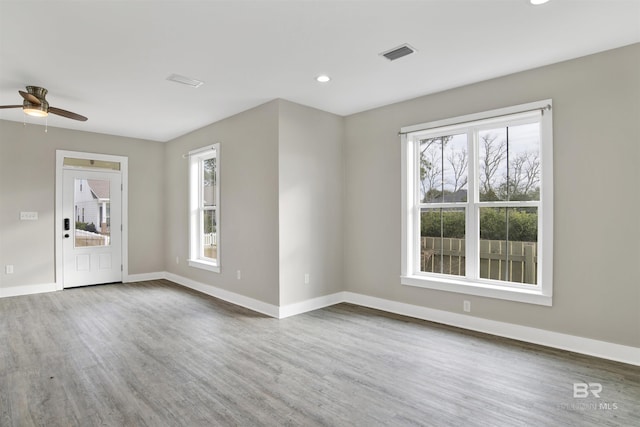 unfurnished room with ceiling fan, a wealth of natural light, and hardwood / wood-style flooring