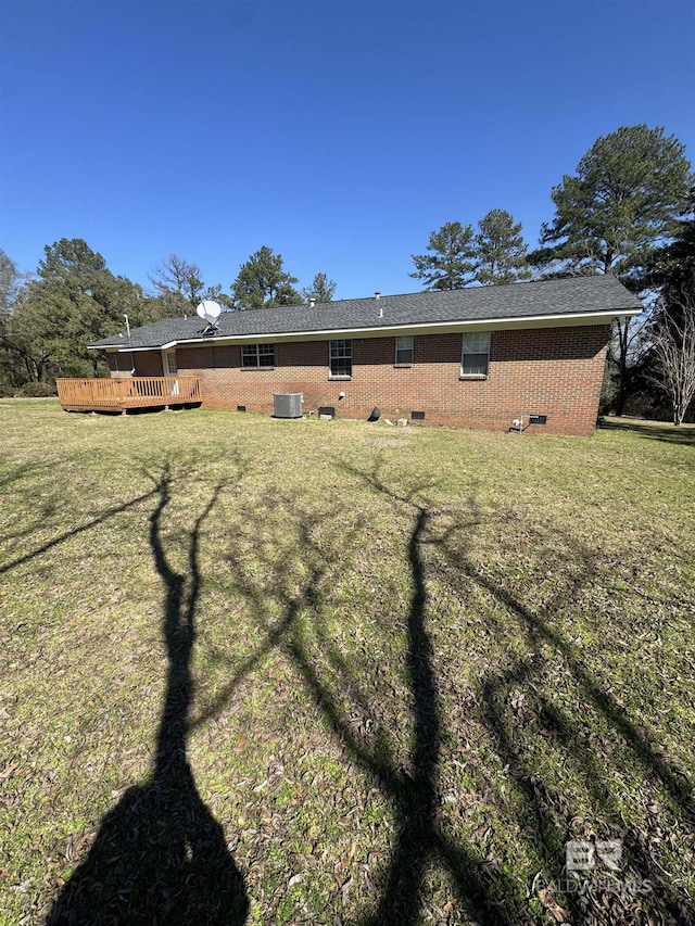 rear view of property with a deck, a yard, and central AC unit