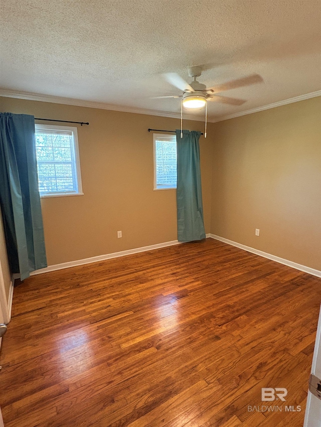 empty room featuring crown molding, wood-type flooring, a textured ceiling, and ceiling fan