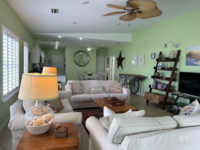 tiled living room with a healthy amount of sunlight and ceiling fan