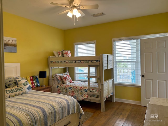 bedroom featuring hardwood / wood-style floors, multiple windows, and ceiling fan