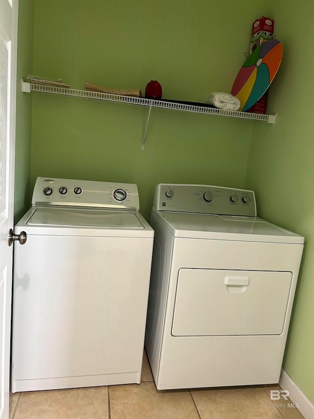 washroom with washer and clothes dryer and light tile patterned floors