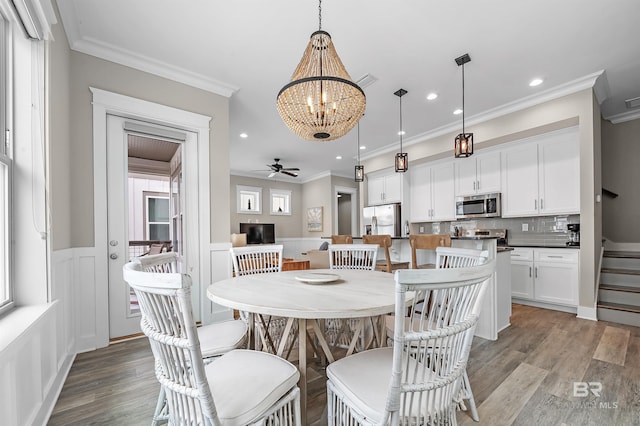 dining room with wainscoting, ornamental molding, light wood-type flooring, and recessed lighting