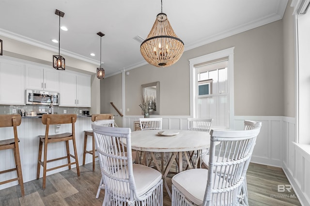 dining area with recessed lighting, dark wood-style flooring, a notable chandelier, and crown molding