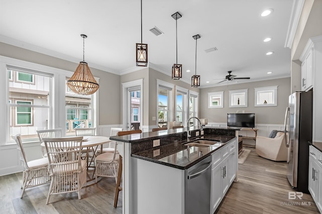 kitchen with visible vents, stainless steel appliances, white cabinetry, pendant lighting, and a sink