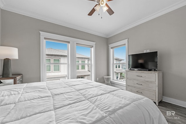 bedroom with crown molding, ceiling fan, wood finished floors, and baseboards