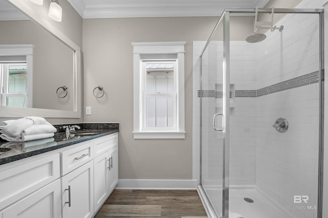 full bathroom featuring a shower stall, vanity, crown molding, and wood finished floors