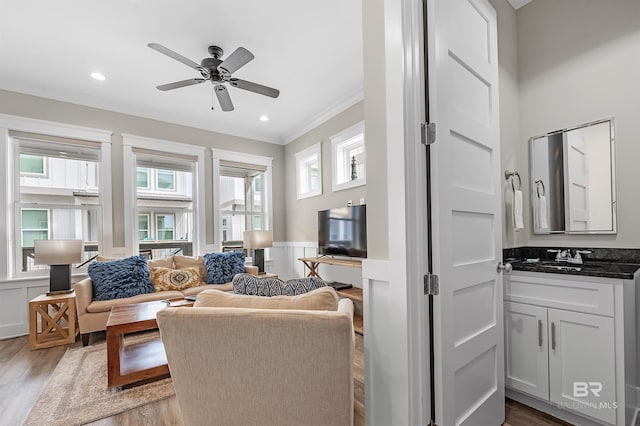 living room featuring wainscoting, recessed lighting, crown molding, and wood finished floors