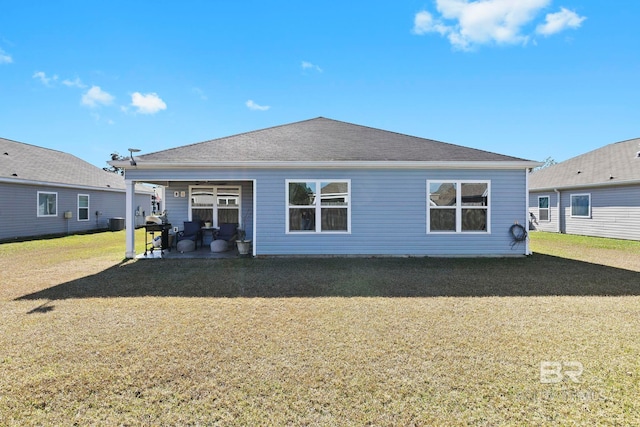 back of property with a lawn and a patio