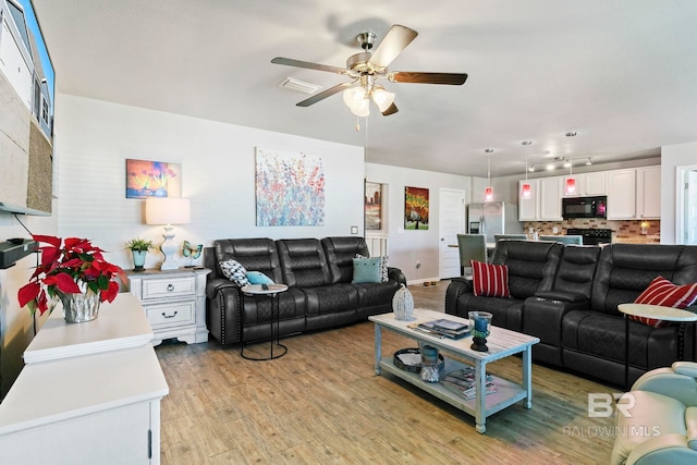 living room with ceiling fan and light hardwood / wood-style flooring