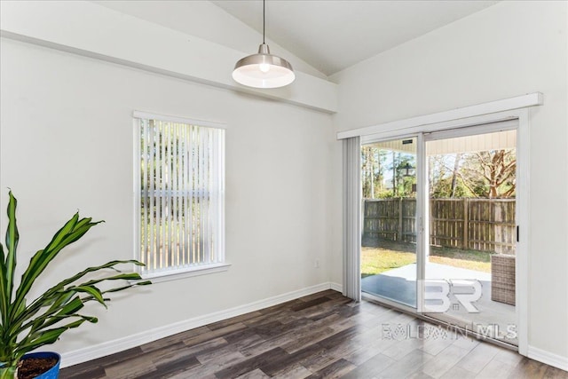 doorway featuring vaulted ceiling, baseboards, and wood finished floors