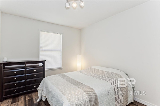 bedroom featuring dark wood-style flooring and baseboards