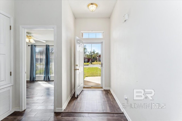 entryway with dark wood-style floors, a wealth of natural light, visible vents, and baseboards