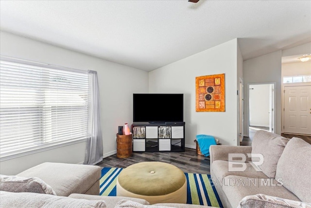 living room with vaulted ceiling, baseboards, and wood finished floors