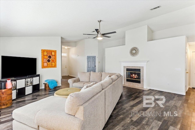 living room featuring dark wood-style floors, a high end fireplace, visible vents, and ceiling fan