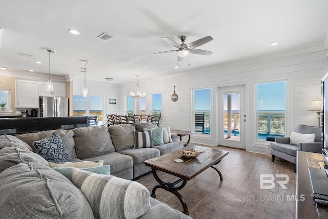 1402 W Dune Dr, Gulf Shores, AL 36542 - living area with dark wood-style floors, visible vents, recessed lighting, ceiling fan with notable chandelier, and crown molding