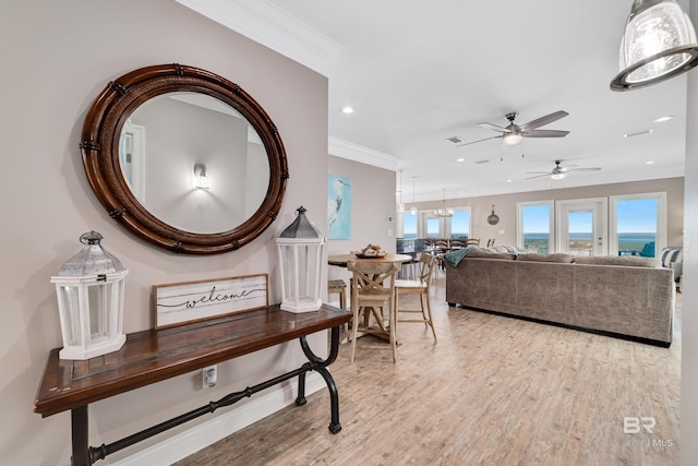 interior space with crown molding, a chandelier, and light hardwood / wood-style floors