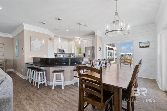 1402 W Dune Dr, Gulf Shores, AL 36542 - dining room with light wood finished floors, baseboards, visible vents, an inviting chandelier, and ornamental molding