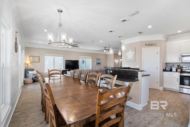 1402 W Dune Dr, Gulf Shores, AL 36542 - dining space with light wood finished floors, visible vents, recessed lighting, ceiling fan with notable chandelier, and ornamental molding