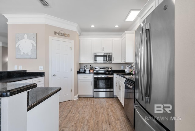 1402 W Dune Dr, Gulf Shores, AL 36542 - kitchen featuring white cabinets, ornamental molding, visible vents, and appliances with stainless steel finishes