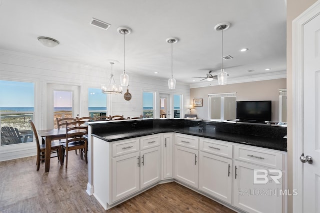 1402 W Dune Dr, Gulf Shores, AL 36542 - kitchen with dark wood-style flooring, dark countertops, visible vents, white cabinetry, and ceiling fan with notable chandelier