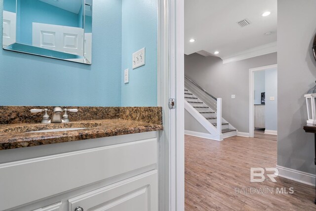 1402 W Dune Dr, Gulf Shores, AL 36542 - bathroom with wood finished floors, visible vents, vanity, crown molding, and baseboards