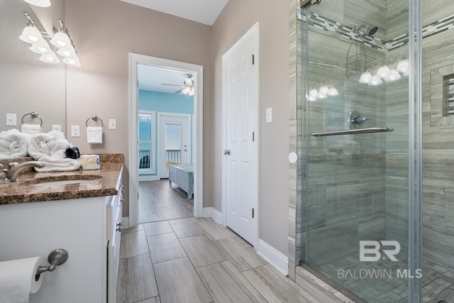 1402 W Dune Dr, Gulf Shores, AL 36542 - bathroom featuring baseboards, a ceiling fan, vanity, and a shower stall
