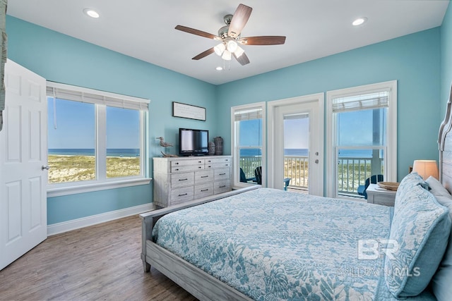 1402 W Dune Dr, Gulf Shores, AL 36542 - bedroom featuring multiple windows, baseboards, access to outside, and wood finished floors