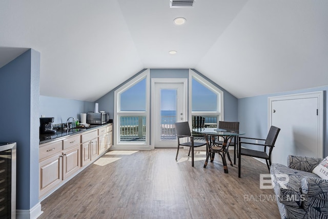 1402 W Dune Dr, Gulf Shores, AL 36542 - dining area with vaulted ceiling, wood finished floors, beverage cooler, and visible vents