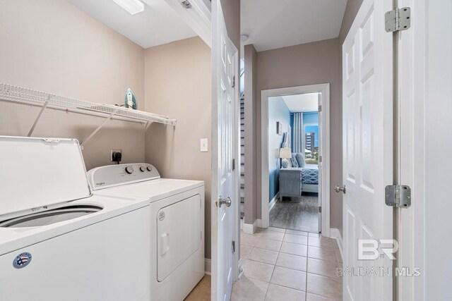 1402 W Dune Dr, Gulf Shores, AL 36542 - washroom featuring washing machine and dryer, baseboards, laundry area, and light tile patterned floors