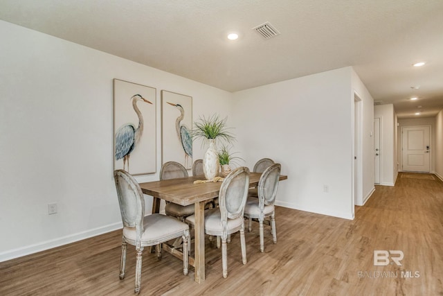 dining space featuring light wood finished floors, baseboards, visible vents, and recessed lighting