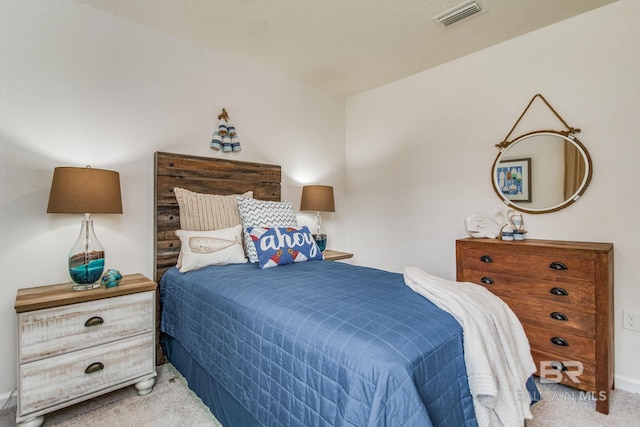 bedroom featuring visible vents and light colored carpet